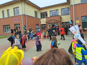 Parada Sobowtorow Kopernika. Na zdjęciu Dyrekcja z goścmi przedszkola oraz kadrą i przedszkolakami otwierają paradę.